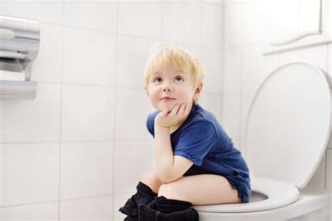 Bambino che fa pipì nel water con paraschizzi