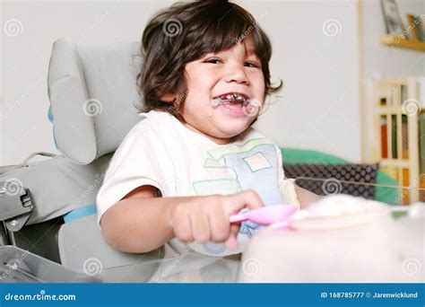 Bambino seduto su una sedia a rotelle Leckey Mygo con un sorriso