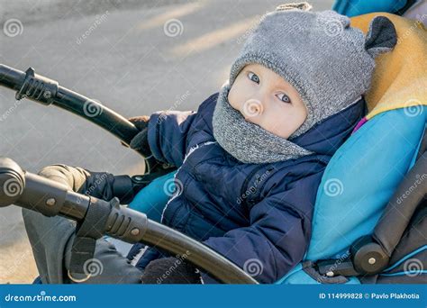 Bambino ben vestito in carrozzina sulla neve