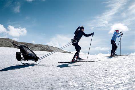 Passeggino con sci anteriore in paesaggio innevato