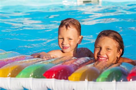bambini che giocano con gonfiabili in una piscina