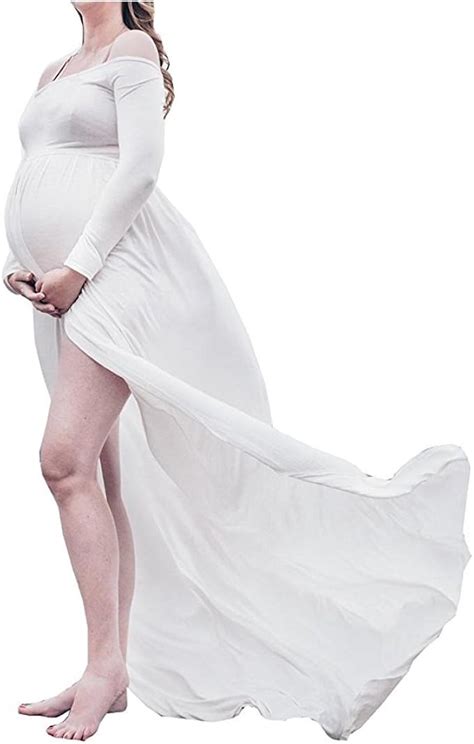 donna incinta con abito in chiffon bianco in un campo al tramonto