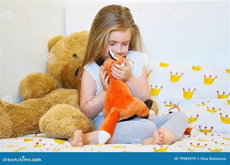 Bambina che abbraccia un orsetto di peluche interattivo