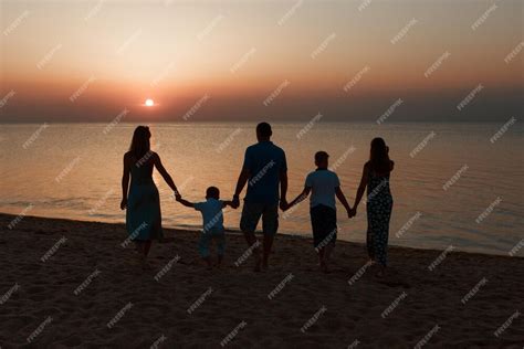 Famiglia che si gode il tramonto in spiaggia