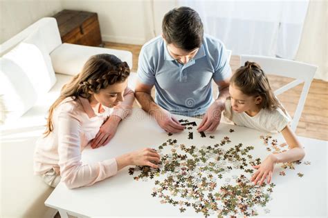Genitori che giocano a un puzzle con la figlia