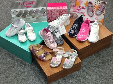 Bambina che sceglie scarpe colorate in un negozio di calzature luminoso