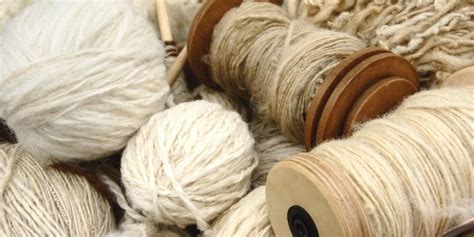 panoramica di tessuti naturali e tecnici di alta qualità su un tavolo da sartoria