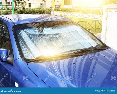 auto parcheggiata sotto il sole cocente con parabrezza protetto