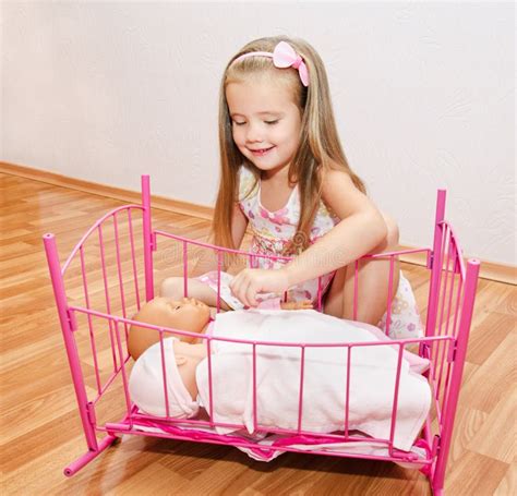 bambina che gioca con una culla per bambole in una stanza colorata