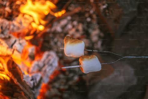 Immagine di marshmallow che vengono arrostiti su un fuoco