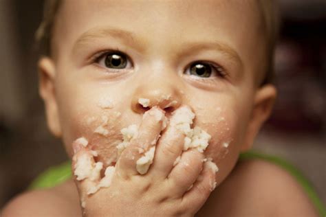Bambino che mangia con le mani