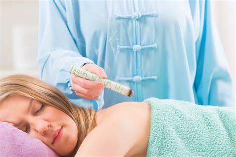 professionista esperto che esegue una seduta di moxibustione su un paziente