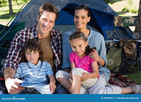 Famiglia felice in campeggio con un bambino che riposa in un lettino