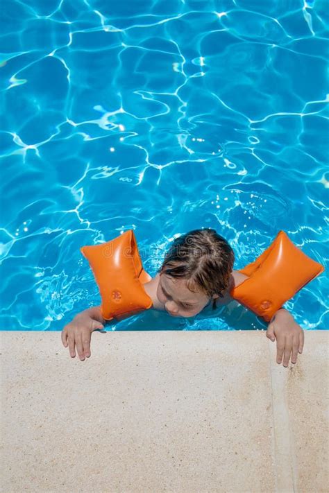 Bambino con braccioli che gioca in acqua