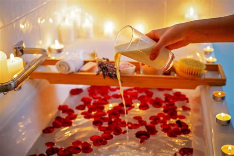 Rituale di bellezza con latte e petali di fiori in una vasca antica