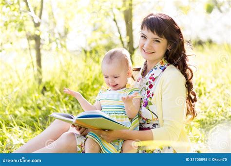 Mamma allatta il suo bambino mentre legge un libro