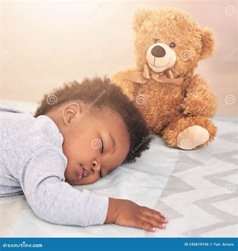 Un bambino piccolo abbracciato a un classico orsacchiotto di stoffa