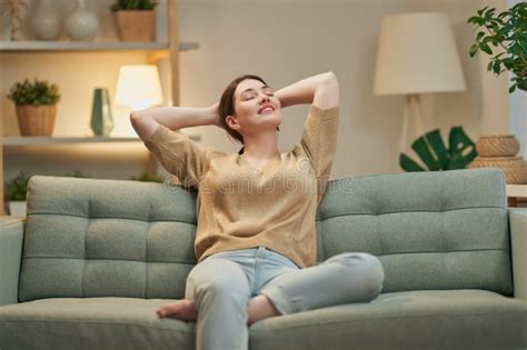 Donna incinta che si riposa su un divano, circondata da decorazioni natalizie