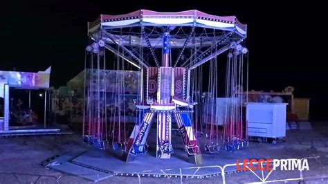 Giostra a seggiolini in un luna park notturno immerso nella nebbia