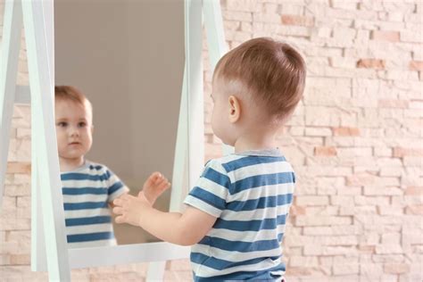 Bambino su materassino con specchio a terra
