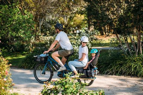 Famiglia in bici con seggiolini e carrelli