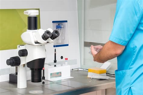 Microscopio con embriologo al lavoro