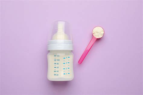 Biberon con latte in formula in polvere e misurino