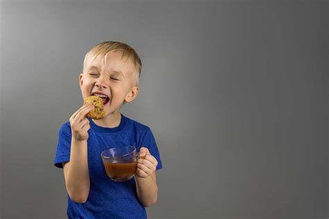 Bambino che sgranocchia un biscotto per l'infanzia