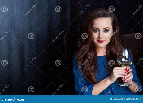 Donna che allatta con un bicchiere di vino in lontananza