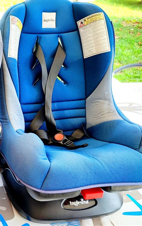 Bambino sorridente seduto in un seggiolino auto blu.