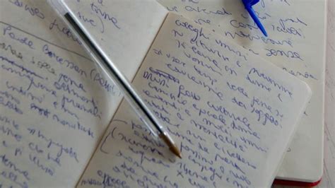 Un quaderno aperto con appunti scritti a mano, posato su un tavolo in legno vicino a un vecchio carillon.