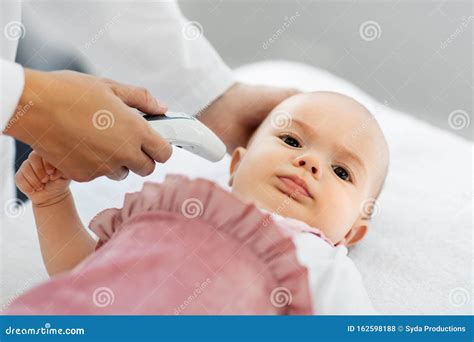 Bambino che misura la temperatura con un termometro
