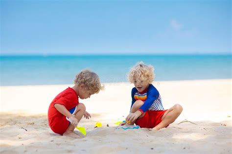 Bambini che giocano in spiaggia sotto l'ombrellone