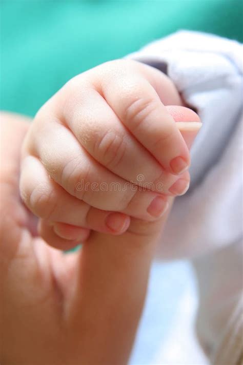 fotografia concettuale di una mano di neonato che afferra delicatamente un dito