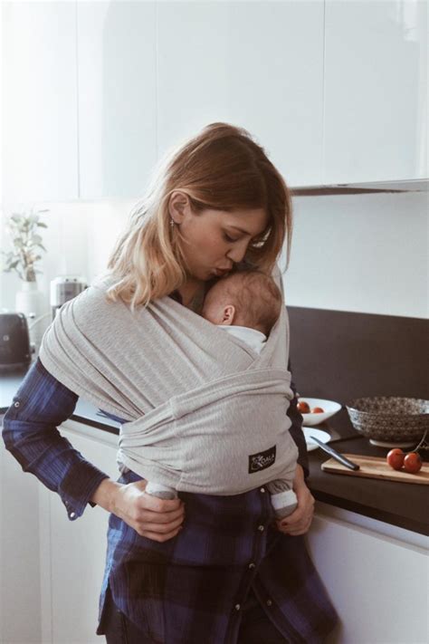 genitore che utilizza una fascia portabebè ergonomica con il proprio neonato