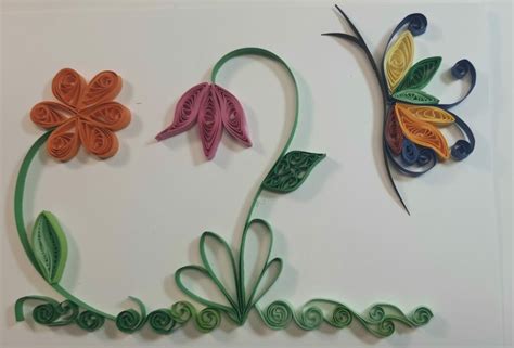 Dettaglio di un nome realizzato con la tecnica del Quilling con decorazioni floreali e animaletti in rilievo