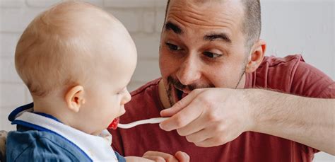 Bambino che gioca con il cucchiaino durante lo svezzamento