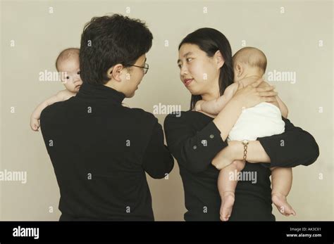Parents happily holding their twin babies