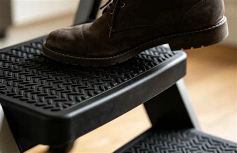 Dettaglio ravvicinato di una superficie antiscivolo su una pedana per passeggino, evidenziando il grip per la sicurezza del bambino