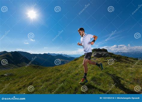 Atleta che corre in montagna indossando abbigliamento tecnico leggero