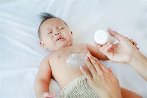 Genitore che applica crema sul bambino dopo il bagno