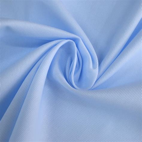 Dettaglio ravvicinato della trama in piquet di cotone che mostra la texture traspirante e il ricamo centrale