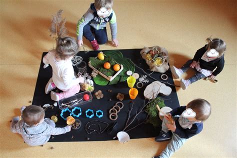 Bambini impegnati in attività di manipolazione artistica con materiali naturali
