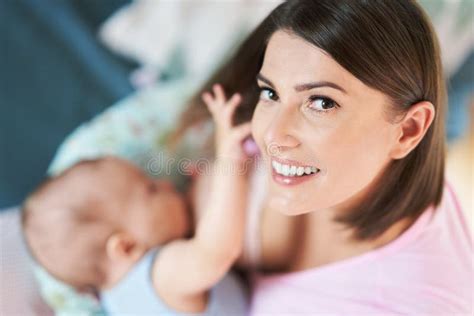 Una madre che allatta con serenità in un ambiente domestico accogliente