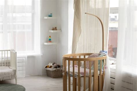 Camera da letto per neonato con lettino in legno scuro e tonalità calde