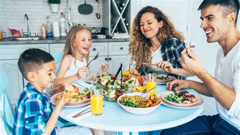 Bambino che scopre i primi alimenti a tavola con i genitori