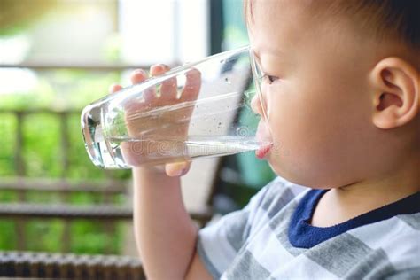 Bambino che beve un bicchiere d'acqua