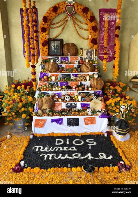 Un elaborato altare domestico (ofrenda) per il Giorno dei Morti, con foto, candele, fiori e cibo