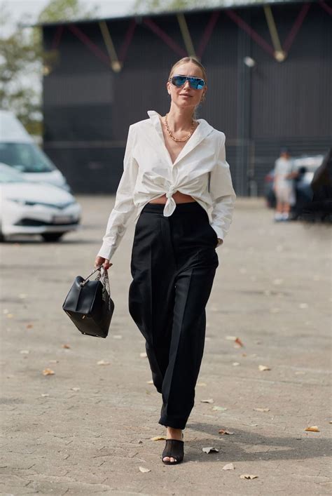 Dettaglio di un outfit con pantaloni della tuta abbinati a una camicia bianca e scarpe col tacco