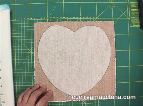 fasi finali di imbottitura di un cuore di stoffa e chiusura con ago e filo